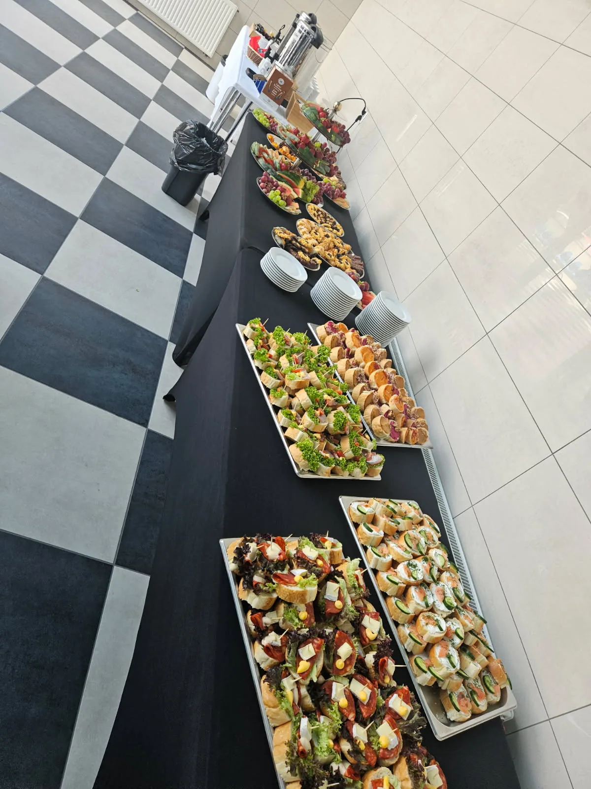 Długi stół z tacami przekąsek przygotowany na catering